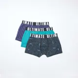 Pack de tres boxers de niño, uno liso color violeta, uno liso color turquesa y uno negro con estampado de circuitos y consolas de videojuegos.