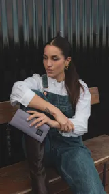 Billetera larga con cierre perimetral, confeccionada en tela capitoneada color gris. Cuenta con correa de mano desmontable, múltiples compartimentos internos para tarjetas, bolsillos organizadores y un bolsillo interno con cierre.