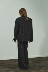 Blazer de corte recto con estampado de cuadros, cuello solapa y manga larga con hombreras. Presenta cierre frontal con botones ocultos bajo solapa y bolsillos delanteros con solapa.