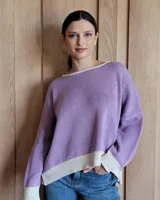 Buzo tostado de corte holgado con cuello redondo y manga larga. Presenta una estrella blanca estampada en la espalda y ribete marrón en cuello y ruedo.