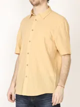 Camisa sport de manga corta, confeccionada en una mezcla de lino y algodón. Presenta cuello clásico, cierre frontal con botones de coco y un bolsillo aplicado en el pecho.