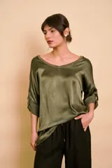 Blusa holgada de satén color beige, con escote en V y mangas largas con trabilla para sujetar remangadas.