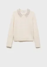 Jersey de punto de textura suave en color crudo, con cuello polo decorado con aplicaciones de strass y manga larga.