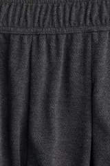 Pantalón de tiro alto, color gris oscuro, de corte amplio y pierna ancha. Presenta cintura elástica y pliegues frontales.