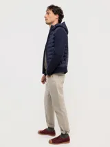 Chaqueta híbrida para hombre con frente acolchado de nylon y mangas de tejido de punto. Cuenta con cierre frontal, capucha y puños acanalados.