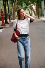 Camiseta de algodón color blanco con cuello redondo, mangas cortas y bajo abullonado, con detalles en color azul marino en el cuello, los puños y el ruedo.