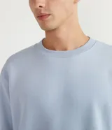 Buzo masculino de fleece color celeste, cuello redondo, manga larga y diseño liso con puños y barra ajustados.