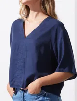 Blusa blanca de lyocell con escote en V y mangas cortas.