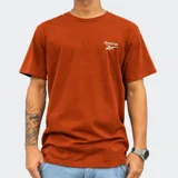 Remera Reebok modelo Volvan Baru de color anaranjado, de manga corta y cuello redondo, con el logo de la marca bordado en el pecho.