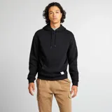 Buzo de chándal negro con capucha ajustable mediante cordones, bolsillo canguro frontal y etiqueta blanca en el dobladillo.