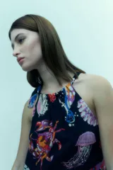 Vestido corto con escote halter y estampado de motivos marinos multicolores sobre fondo azul marino.