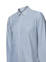 Camisa de manga larga para hombre, con cuello camisero y rayas verticales finas en tonos azul claro y blanco. Presenta un pequeño logo bordado en el pecho.