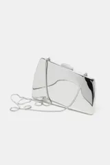 Bolso tipo clutch rígido con acabado metálico dorado y diseño geométrico. Incluye cadena metálica extraíble y cierre de doble clip.