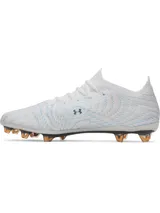 Championes de fútbol Under Armour Shadow Elite 4 Mach FG, color blanco con detalles en azul y naranja. Presentan una placa de fibra de carbono optimizada para mayor agilidad, microtextura háptica 3D en el empeine para un contacto óptimo con el balón y cuello elástico de punto para un ajuste ceñido.