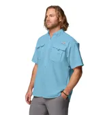 Camisa de manga corta Columbia modelo Bahama II S/S Shirt, color celeste, de ajuste relajado y tejido de nailon de secado rápido. Cuenta con cuello abotonado, bolsillos frontales con solapa, presilla para caña de pescar y ventilación en la espalda con forro de malla.