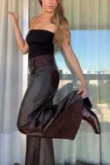 Pantalon de corte wide leg confeccionado en una combinación de cueros ovinos en tonos chocolate, incluyendo paneles de cuero liso, cuero desgastado y gamuza suave. Presenta diseño de cinco bolsillos y cierre frontal.