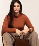 Blusa de viscosa con elastano color ladrillo, con cuello alto y mangas largas. Corte ajustado al cuerpo.