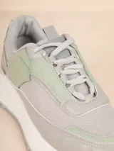 Zapatillas blancas acordonadas con plataforma de 4cm, con recortes en mesh y símil cuero, y detalle dorado en el talón.