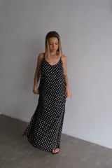 Vestido largo color bordó con estampado de lunares blancos, escote en V y tirantes finos.