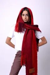 Bufanda de lana merino tejida en telar, con diseño de rayas en tonos marrón, beige y rojo. Presenta flecos en los extremos y un parche negro con la palabra "CAPER" en blanco.