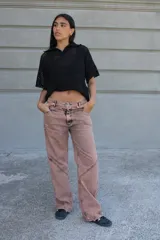 Jean de corte recto y tiro medio, color rosado con efecto acid wash y costuras diagonales en negro.