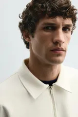 Sudadera polo azul marino de corte regular fit, confeccionada en tejido técnico interlock de algodón con elasticidad. Presenta cuello solapa, cierre frontal de cremallera y manga larga con acabados en rib.