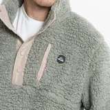 Campera de polar tipo borreguito color verde oliva, con cuello alto, cierre frontal parcial con botones a presión y bolsillo en el pecho con cierre. Presenta detalles en color beige en la solapa y los bordes.