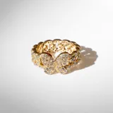 Anillo dorado de acero con eslabones y diseño de mariposa en el frente, cubierto de cristales claros tipo Cubic Zirconia.