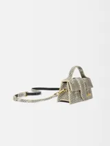 Bolso pequeño estructurado con estampado de piel de serpiente en tonos blanco y negro, con asa superior acolchada y correa larga extraíble. Cierre magnético con solapa, bolsillo trasero y herrajes dorados.