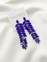 Aros colgantes largos con forma de hojas, con engarce dorado y piedras de fantasía color azul.