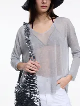 Sweater negro de lurex con escote en V, mangas largas y aberturas laterales.