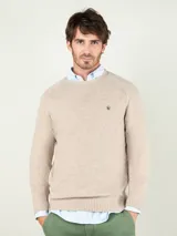 Sweater de lana merino color camel, de cuello redondo, mangas largas y diseño clásico, con pequeño logo bordado en el pecho.