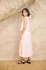 Conjunto negro de dos piezas de lino, compuesto por un top de un hombro con bordados florales y una falda midi con aberturas laterales y bordados florales.