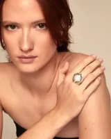 Anillo plateado con una perla blanca en el centro.