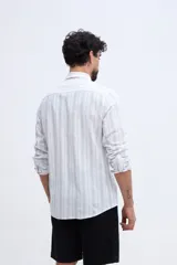 Camisa de manga larga con diseño de rayas verticales, confeccionada en mezcla de lino y algodón, con cuello camisero y cierre frontal de botones.