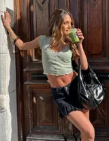 Mini falda marrón con volados en el ruedo y cinturón negro.