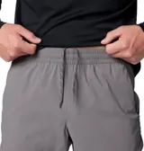 Pantalón técnico Columbia de corte ajustado en color gris, con cintura elástica ajustable mediante cordón y puños elásticos en los tobillos. Presenta paneles reforzados en la parte superior y bolsillos laterales y traseros con cierre.