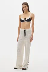 Pantalón de calado color blanco, de silueta recta y caída suave, con cintura elastizada y cordón ajustable.