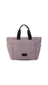 Cartera tipo tote de nylon color malva, con diseño capitoneado de líneas verticales en el frente y rombos en los laterales. Cuenta con doble asa de mano en color negro, bolsillos laterales y un parche decorativo con logo en la parte frontal.