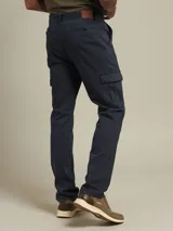 Pantalón cargo de gabardina color azul marino, con bolsillos laterales con fuelle y cierre de botón a presión.