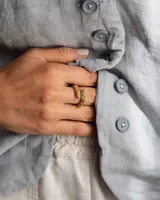 Anillo abierto de diseño orgánico con textura irregular y acabado brillante, realizado artesanalmente en metal.