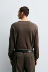Jersey de punto con mezcla de algodón y cashmere, de corte regular y manga larga. Presenta cuello redondo con cierre frontal de dos botones y acabados en rib.