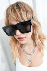 Lentes de sol rectangulares oversized de estilo tecno, con marco negro y cristales oscuros. Ofrecen filtro de protección UV 400 que bloquea rayos UVA y UVB.