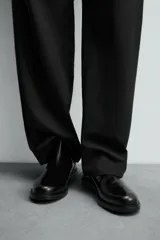 Bota estilo Chelsea de piel negra con elásticos laterales y suela con ligero tacón.
