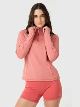 Polera deportiva de manga larga en color rosa melange, con cuello alto y cierre frontal parcial. Presenta un diseño ajustado con costuras visibles y aberturas para los pulgares en los puños.