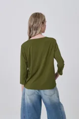 Remera de poliéster color verde oliva, con mangas 3/4, cuello en V con detalle de pliegue central y corte holgado.