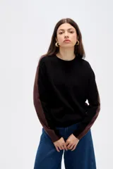 Sweater de viscosa con diseño color block, combinando frente negro con mangas y laterales en tono marrón. Presenta cuello redondo a la base y mangas largas.