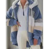 Campera peluda de mujer marca United Uy, con capucha y cierre frontal de cremallera. Presenta diseño de rayas horizontales en bloques de colores blanco, gris, beige y negro, con textura de piel sintética y puños elásticos.