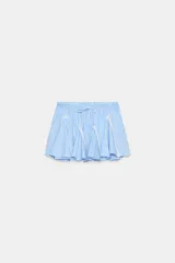 Falda mini de tiro medio con estampado de rayas celestes y blancas. Cuenta con cintura elástica ajustable con cordones, detalles de entredós en contraste y bajo con volantes.