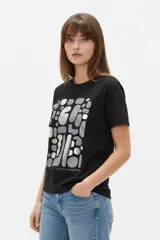 Remera de manga corta de algodón en color blanco, con cuello redondo y diseño holgado. Cuenta con un estampado frontal central con detalles metalizados estilo foil.